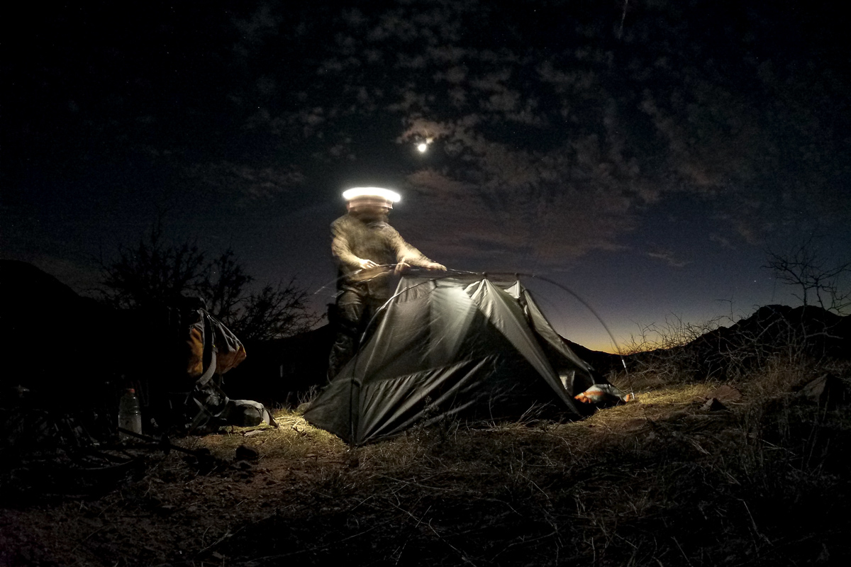 Eric Voris packing up camp via headlamp on a solo hunt 