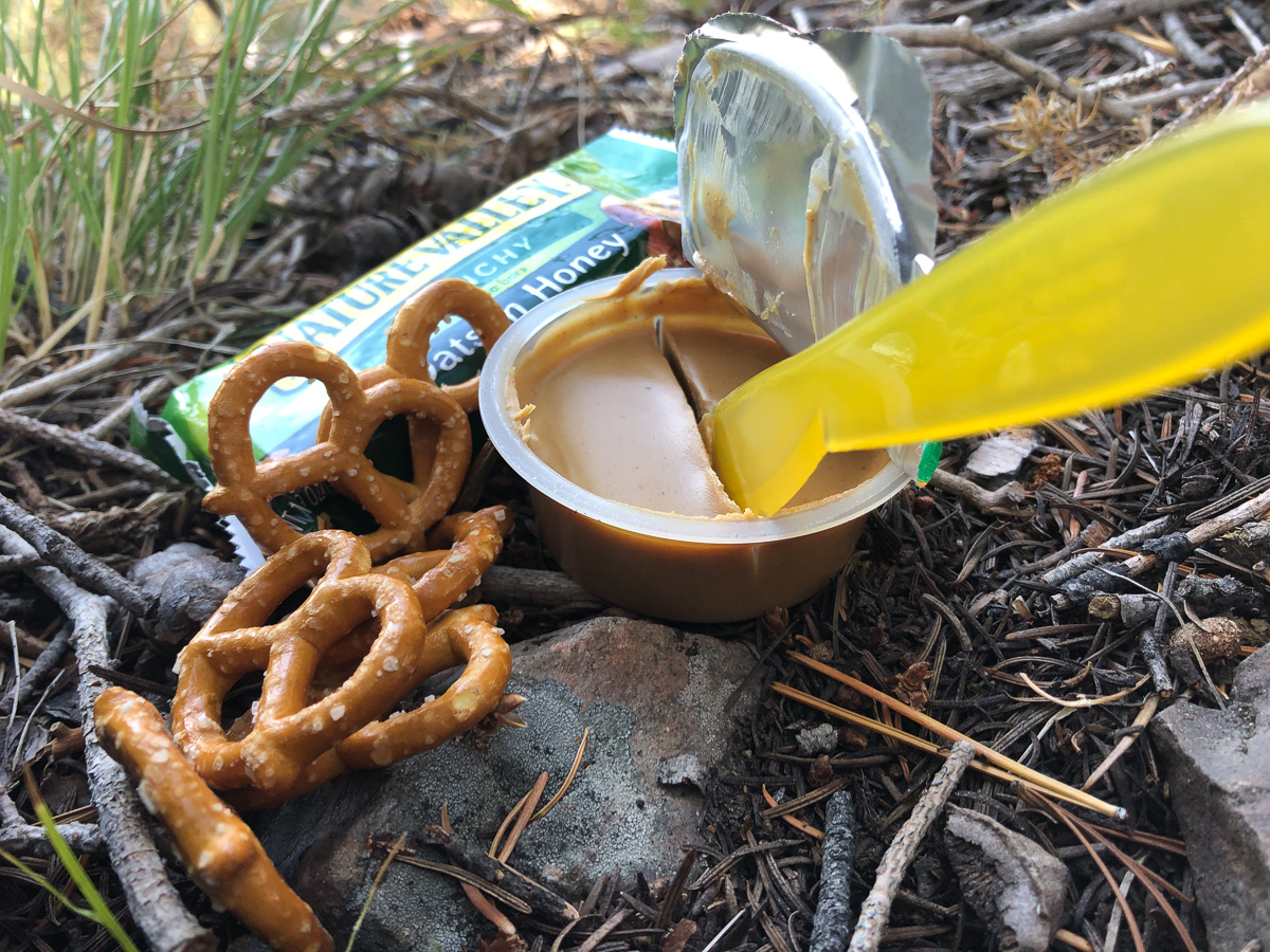 Kyle Kamp of Valley to Peak Nutrition eating pretzels and peanut butter in the backcountry
