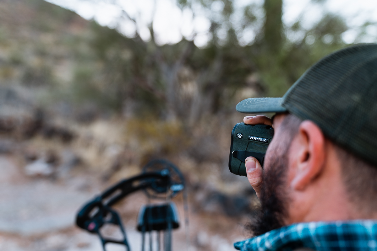 Bowhunter using Vortex rangefinder to range a target while sighting in his bow